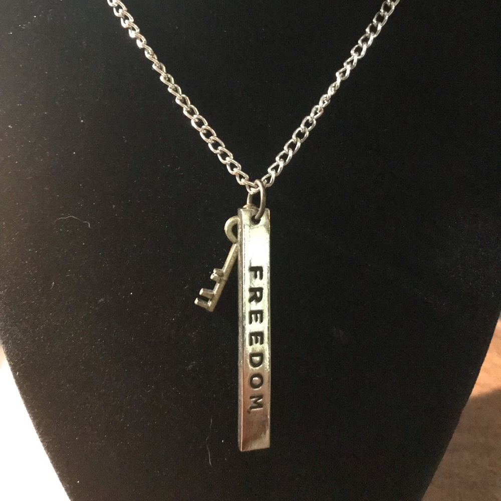 Stainless bar says Freedom with a tiny brass key necklace